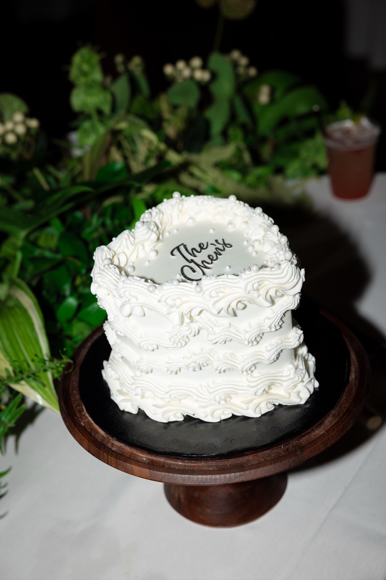 The Chen's wedding cake with white ruffled frosting and pearl details at The Colony House