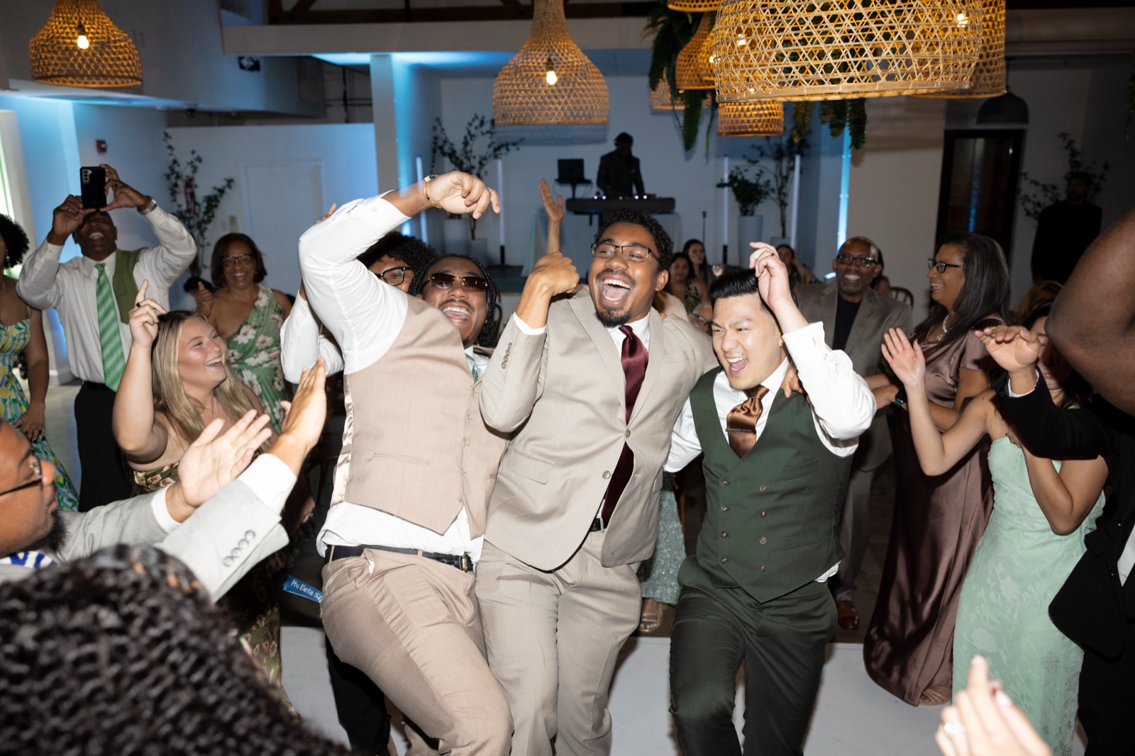 Groomsmen and guests dancing together at The Colony House wedding reception