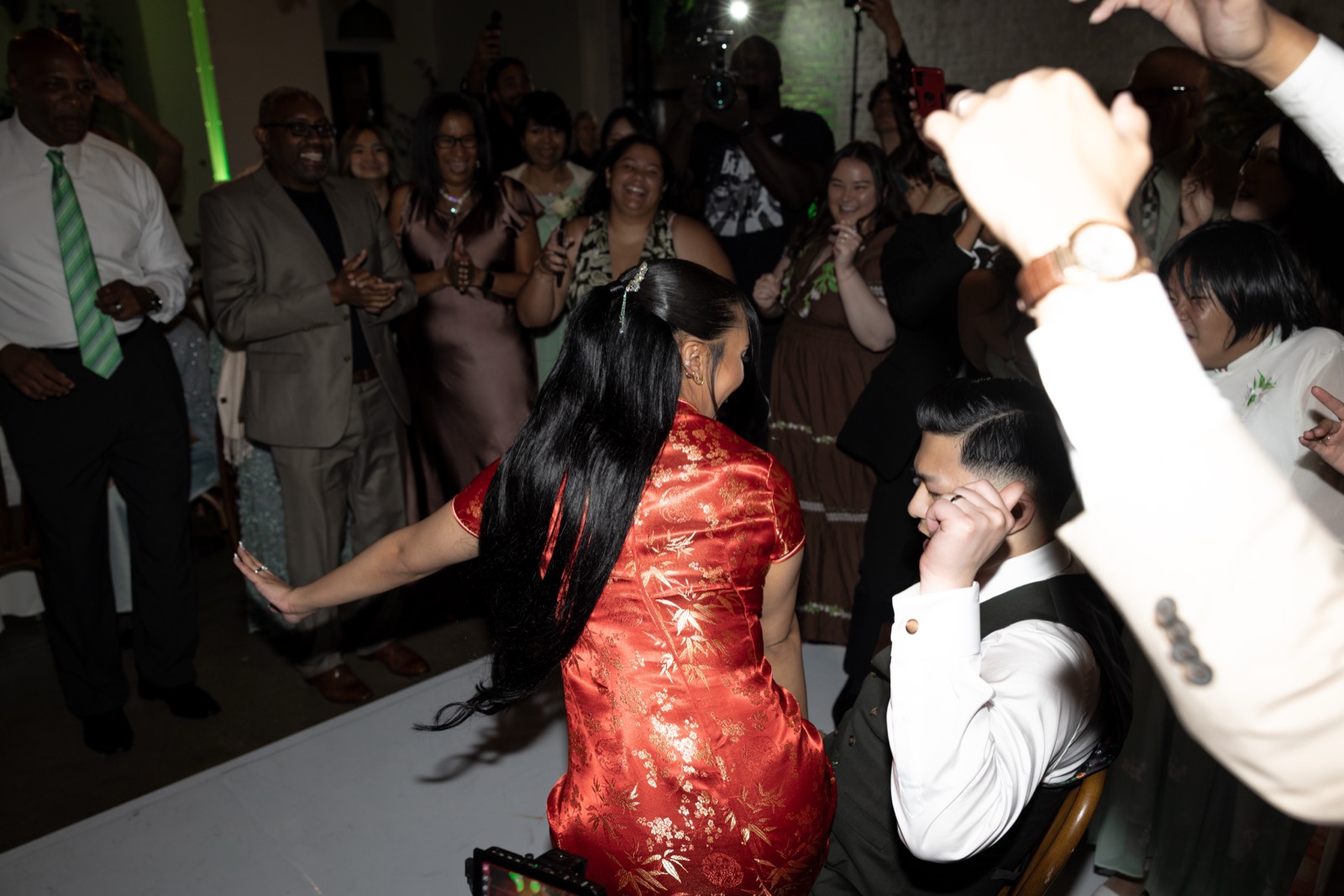 Kevin and Rachel on the dance floor surrounded by guests, Rachel in red qipao