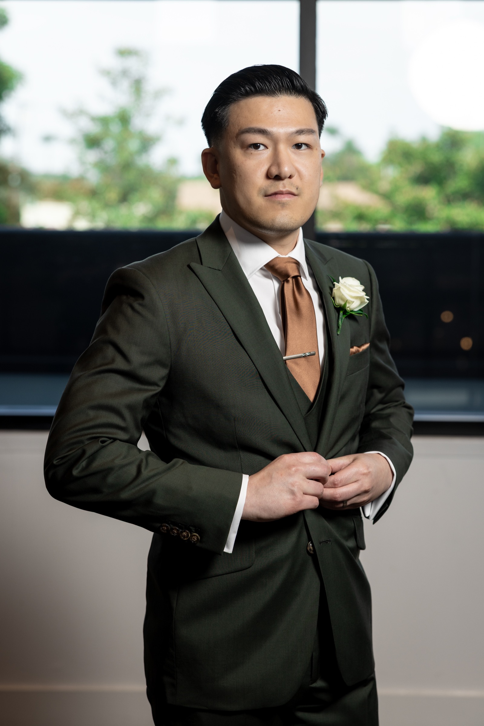 Kevin in his dark green suit with copper tie, groom portrait at The Colony House wedding