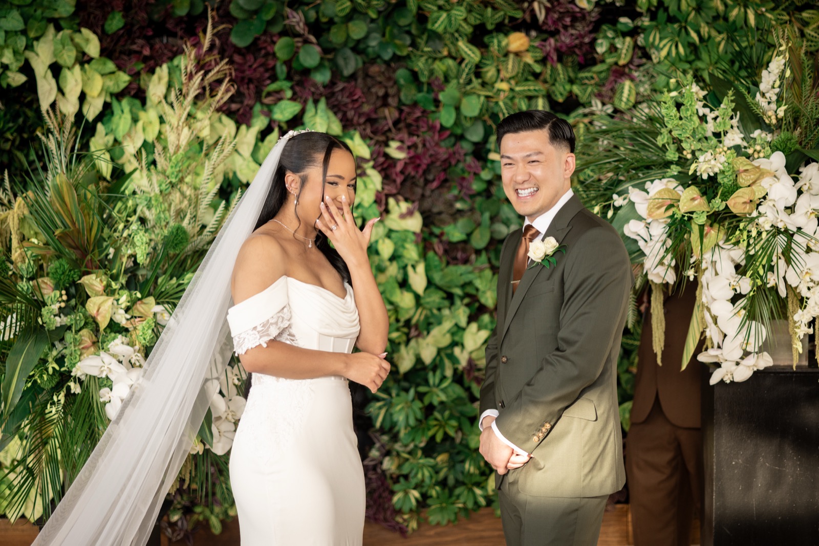 Rachel smiling with her white rose bouquet at The Colony House wedding