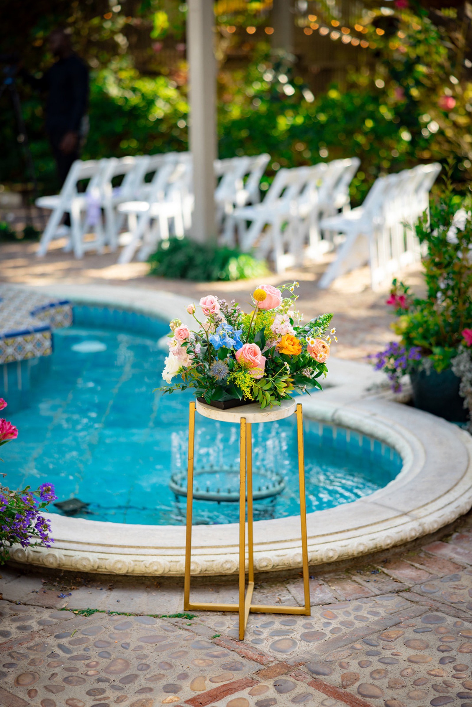 Ceremony setup with floral arrangements by the fountain at Sherman Library and Gardens