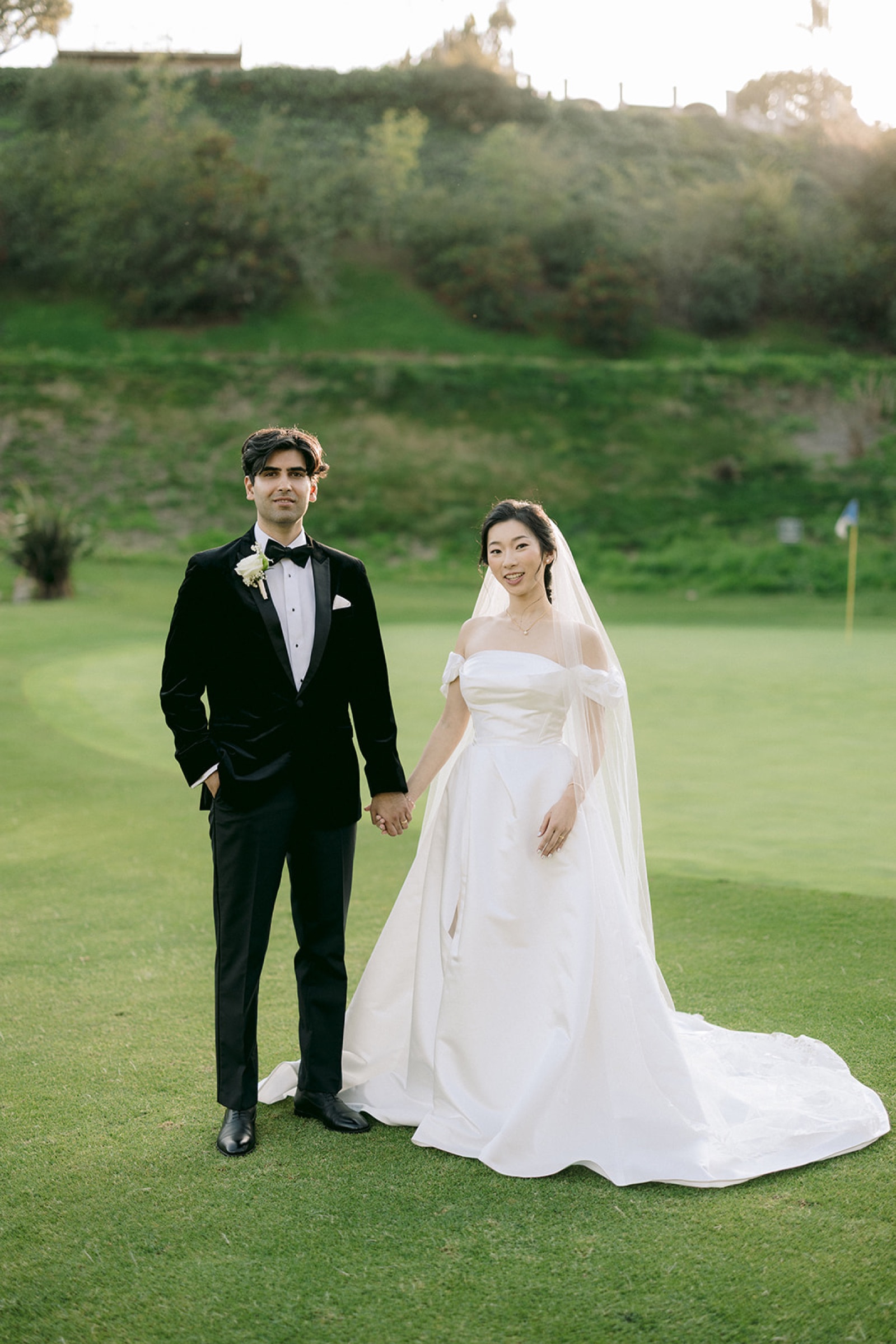 Kirsten and Shravan standing on the golf course at golden hour